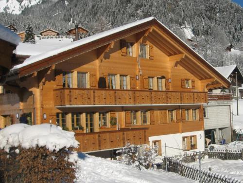 duży drewniany budynek ze śniegiem w obiekcie Chalet uf em Stutz 2 w mieście Grindelwald