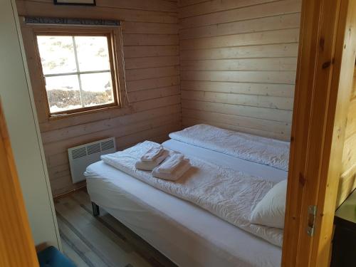 Dos camas en una habitación con ventana. en Stundarfriður cottages, en Stykkishólmur