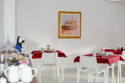 a dining room with red tables and white chairs at BnB acasaconme in Lucito