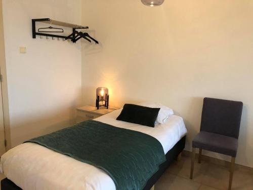 1 dormitorio pequeño con 1 cama y 1 silla en Apartment Fruithof Tack, en Sint-Gillis-Waas