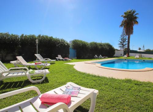 un grupo de sillas de césped y una piscina en Townhouse Palm Beach by Algarve Vacation, en Albufeira