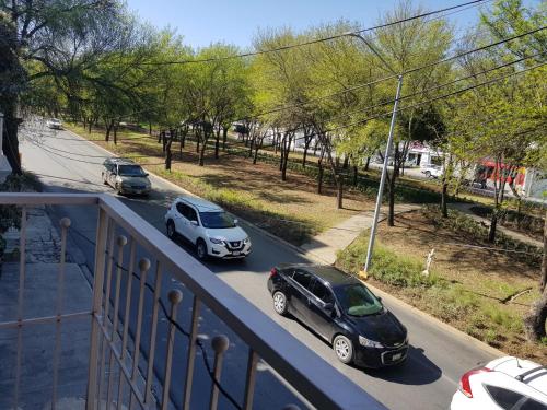 two cars are parked on a street with trees at Contry La Silla Apartments zona tec - Nuevo Sur in Monterrey