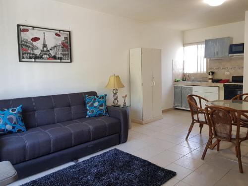 a living room with a blue couch and a table at Contry La Silla Apartments zona tec - Nuevo Sur in Monterrey
