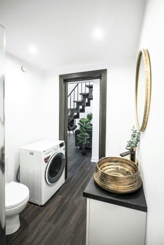 Un baño con lavadora y un inodoro. en Luxury Loft, en Kaunas