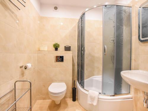 a bathroom with a shower and a toilet and a sink at VacationClub – Osiedle Podgórze 1E Apartament 19 in Szklarska Poręba