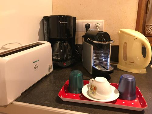 a kitchen counter top with a coffee maker and cups at Maison de Vacances MACOU 2 in Capdrot