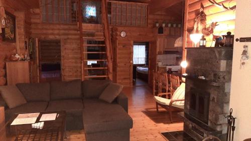 a living room with a couch and a fireplace at Kallioranta Cottage in Ruokolahti