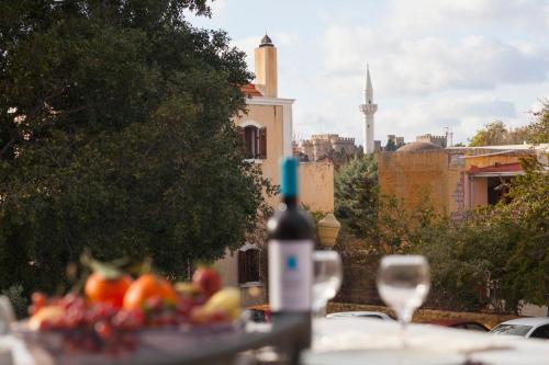 a table with a plate of fruit and a bottle of wine at Medieval Dreams Villa in Rhodes Town