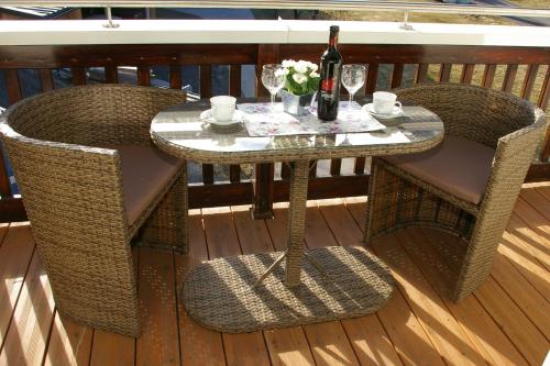 uma mesa ao ar livre com duas cadeiras e uma garrafa de vinho em Imsterberger Auszeit em Imsterberg