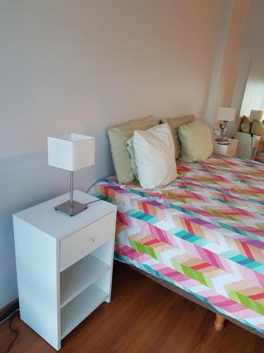 1 dormitorio con 1 cama y vestidor con lámpara en Duplex Cabildo en Buenos Aires
