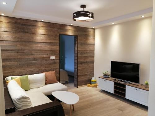 チェペラレにあるАпартамент Легалのリビングルーム(白いソファ、テレビ付)