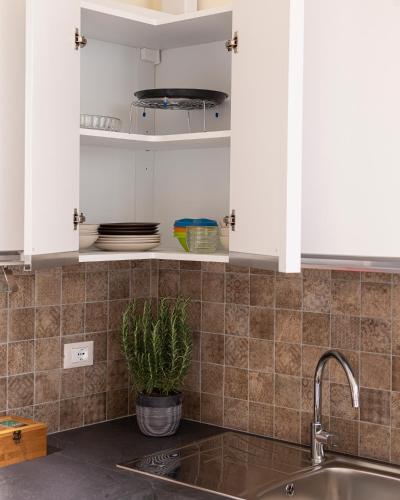 a kitchen with white cabinets and a sink at Sui Tetti, Caressa de mä in Bordighera