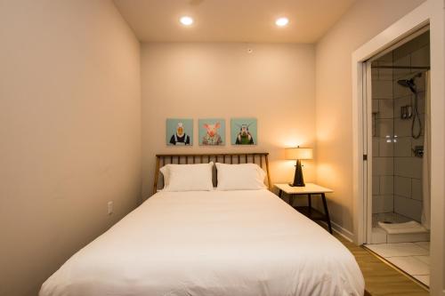 ein Schlafzimmer mit einem großen weißen Bett und einer Dusche in der Unterkunft The Hotel at Huntington Square in Jonesboro