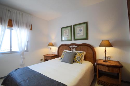 a bedroom with a bed and two lamps and a window at Las Eras - La casa frente al mar in Las Eras