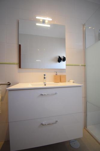 a white bathroom with a sink and a mirror at Las Eras - La casa frente al mar in Las Eras