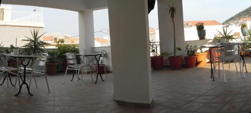 a patio with chairs and tables and potted plants at Pension Niki in Kalymnos
