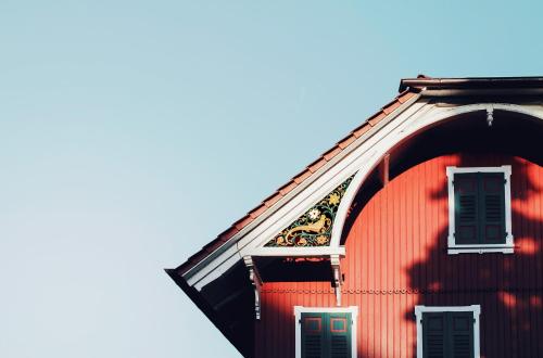 a red building with a blue sky in the background at Hotel Haus am See in Nonnenhorn