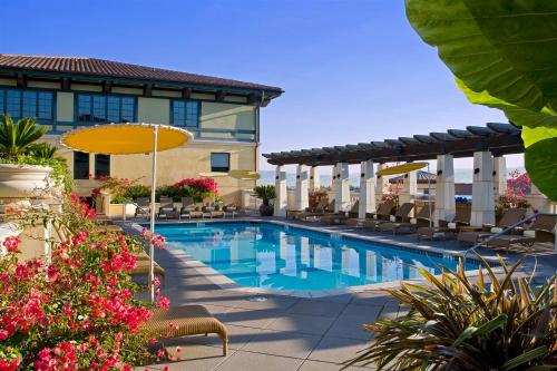 
a patio with a pool and a pool umbrella at Hotel Valencia Santana Row in San Jose
