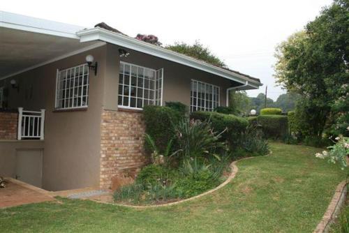 a house with a grass yard in front of it at Firenze in Kloof