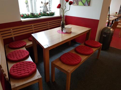 a table and stools with red cushions on them at Hotel am Brauerei-Dreieck in Bamberg