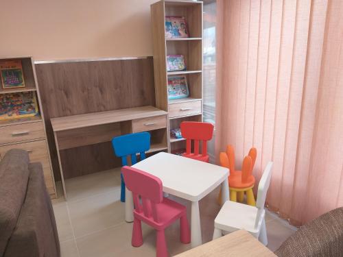 a toy kitchen with a table and four chairs at M7 Galéria Panzió in Letenye
