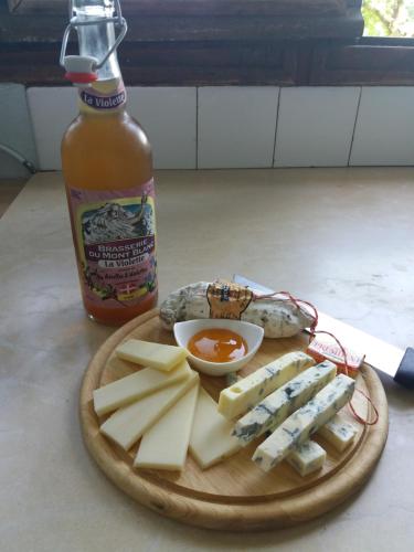 a plate of food with a bottle of hot sauce and cheese at Hotel Restaurant Le Traineau in Clelles