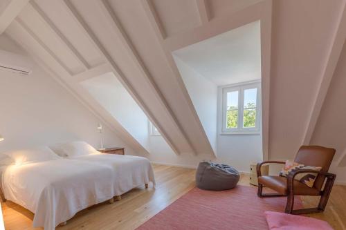 1 dormitorio con 1 cama, 1 silla y 1 ventana en S. Pedro 27, en Sintra