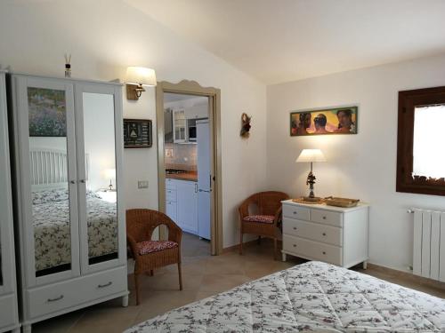a bedroom with a bed and a dresser and a mirror at Lu Nidu in Olbia