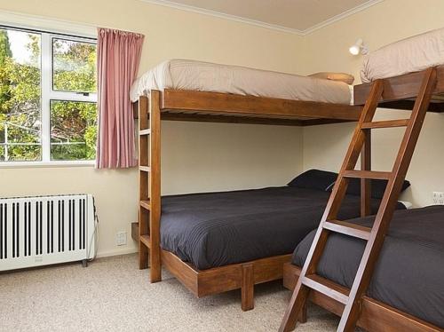 a bedroom with two bunk beds and a window at Kune Crib - Ohakune Holiday Home near Turoa in Ohakune