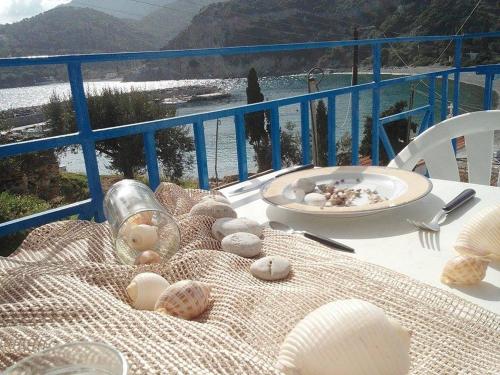 a table with shells and a plate on a balcony at Armenaki Apartments in Sampatiki
