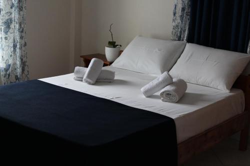 a bed with white pillows and towels on it at Armenaki Apartments in Sampatiki