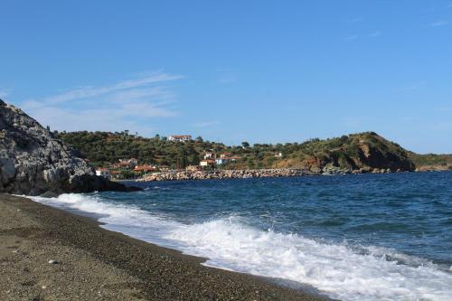 a beach with a rocky shore and the ocean at Armenaki Apartments in Sampatiki