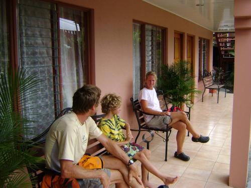 a group of people sitting in chairs on a porch at Hotel La Choza Inn in Fortuna