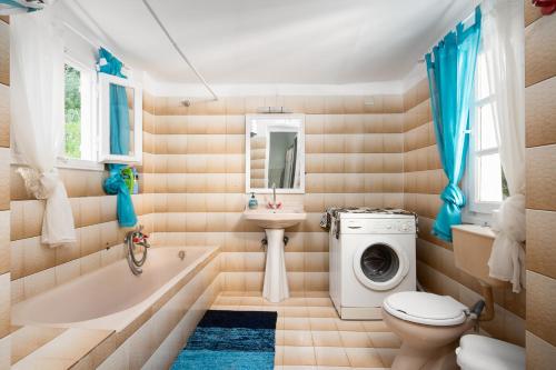 ein Badezimmer mit einem Waschbecken und einer Waschmaschine in der Unterkunft Villa Spiaggia Bianca in Dafnila