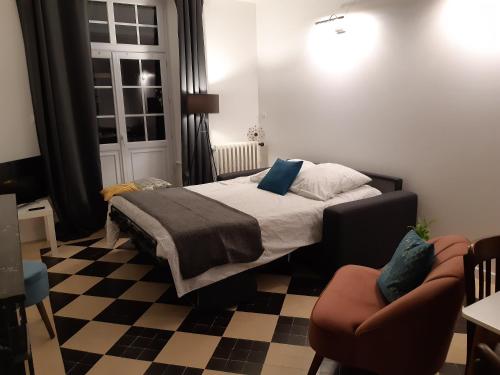 a bedroom with a bed and a checkered floor at La maison d'à côté in May-sur-Orne