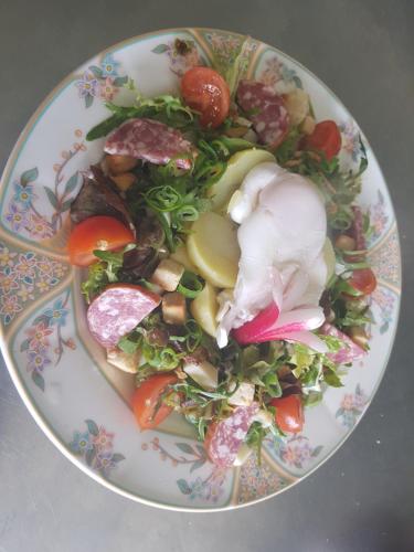 a plate of food with vegetables on a table at Hotel Restaurant Le Traineau in Clelles