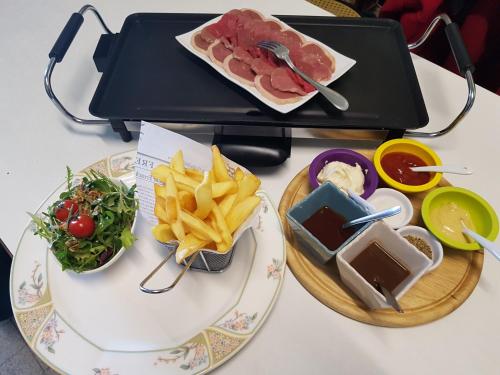 a table with two plates of food and french fries at Hotel Restaurant Le Traineau in Clelles