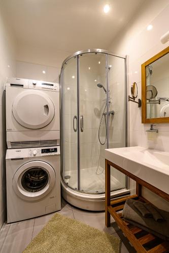 a bathroom with a shower and a washing machine at Liepaja Apartments Downtown in Liepāja
