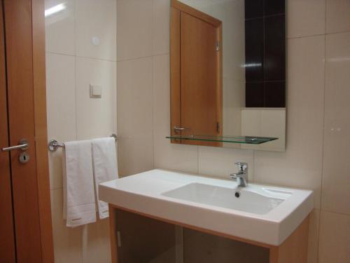 a bathroom with a white sink and a mirror at Mantamar Apartamentos in Manta Rota