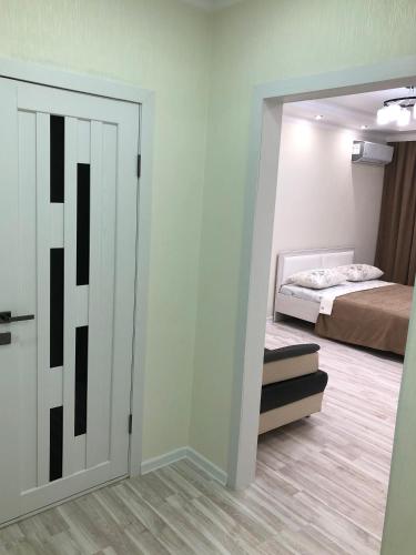 a room with a bedroom with a bed and a mirror at Apartment Батыс 2, 44 in Aktobe