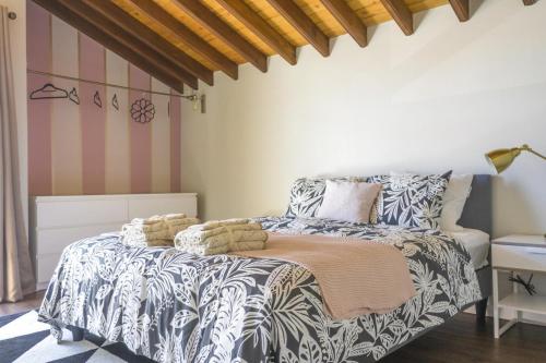 ein Schlafzimmer mit einem Bett mit einer schwarz-weißen Bettdecke in der Unterkunft Beach House DeLuxe in Glória