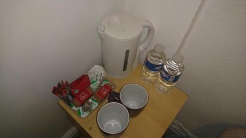 a table with a trash can and two cups on it at MyRoomz Orchid Hotel in Blackpool
