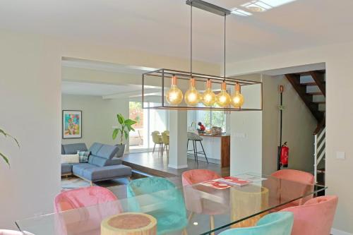 a dining room with a glass table and colorful chairs at Beach House DeLuxe in Glória