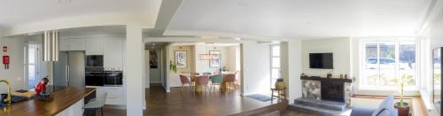 a kitchen and a living room with a fireplace at Beach House DeLuxe in Glória