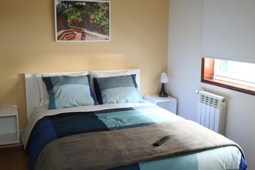 um quarto com uma cama com um controlo remoto em Arouca Guest House em Arouca