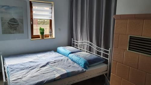 1 cama pequeña en un dormitorio con ventana en Ferienhaus Deubetal Nr.10, en Stadtilm