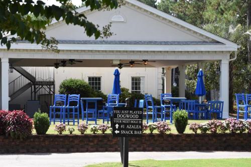 een groep blauwe stoelen en parasols op een patio bij Pool View Villa 1504 with Golf Course in Calabash