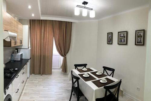 a kitchen with a table and chairs in a room at Apartment Батыс 2, 44 in Aktobe