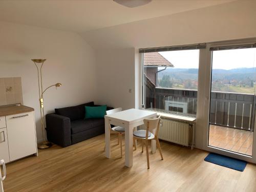 ein Wohnzimmer mit einem Tisch und einem Sofa in der Unterkunft Gemütliche Ferienwohnung Harz Braunlage Hohegeiß in Braunlage