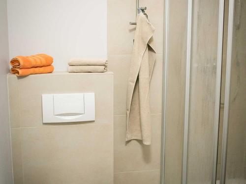 a bathroom with a shower with towels on a shelf at Forsthaus Leiner Berg in Dessau